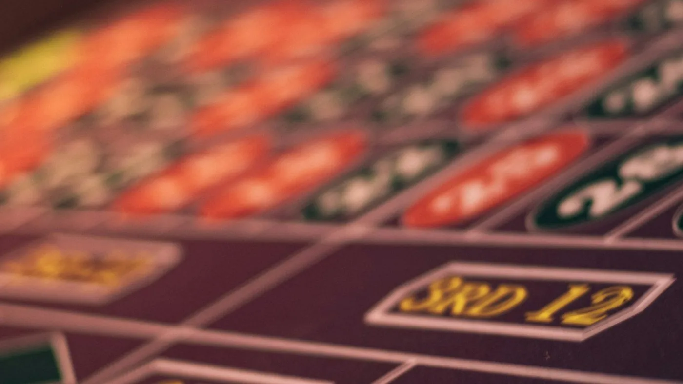 Mesa de ruleta de casino con fichas y apuestas sobre el tapete verde